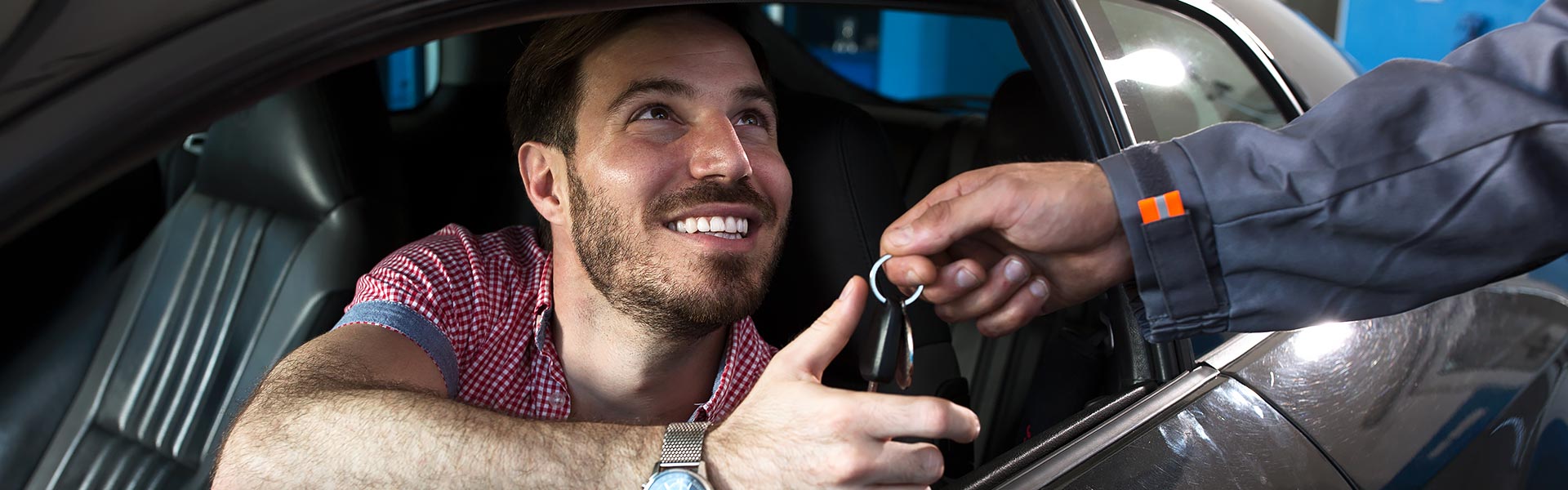man in car--salesman passing keys
