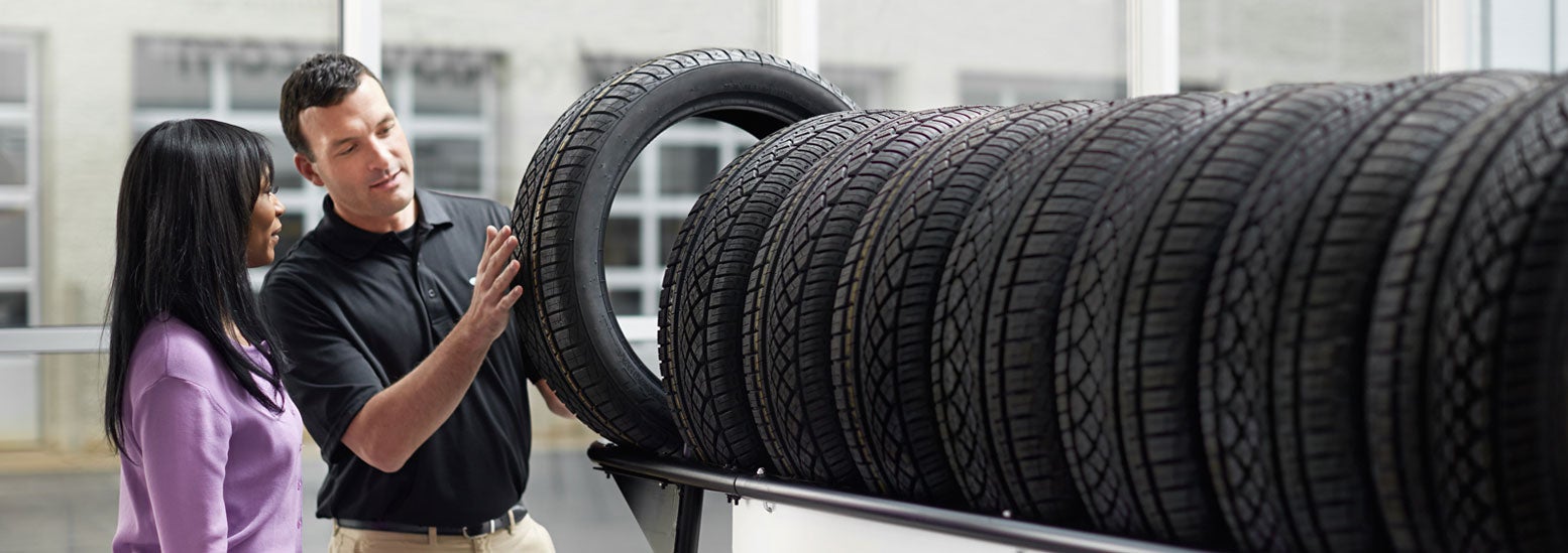 Subaru service representative showing customer a tire. | Fitzgerald Subaru Clearwater in Clearwater FL